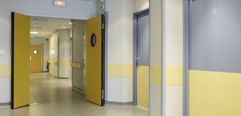 Couloir d'hôpital avec portes jaunes.
