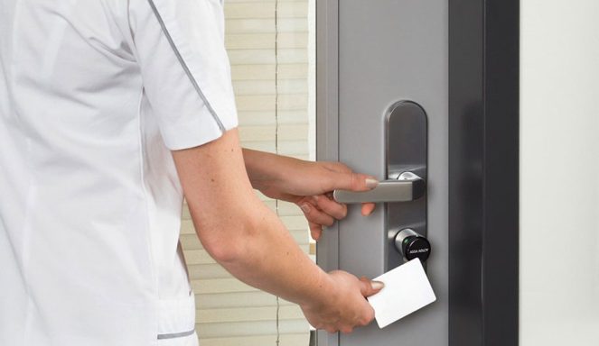 Une personne utilise une carte pour déverrouiller une porte.
