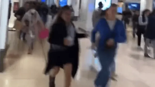 Gens marchant rapidement dans un centre commercial animé.