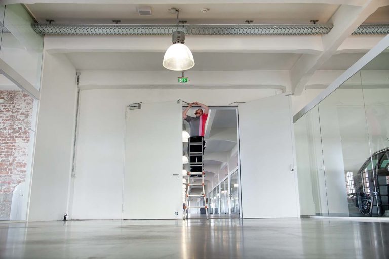 Un technicien procède à un réglage de porte d'atelier